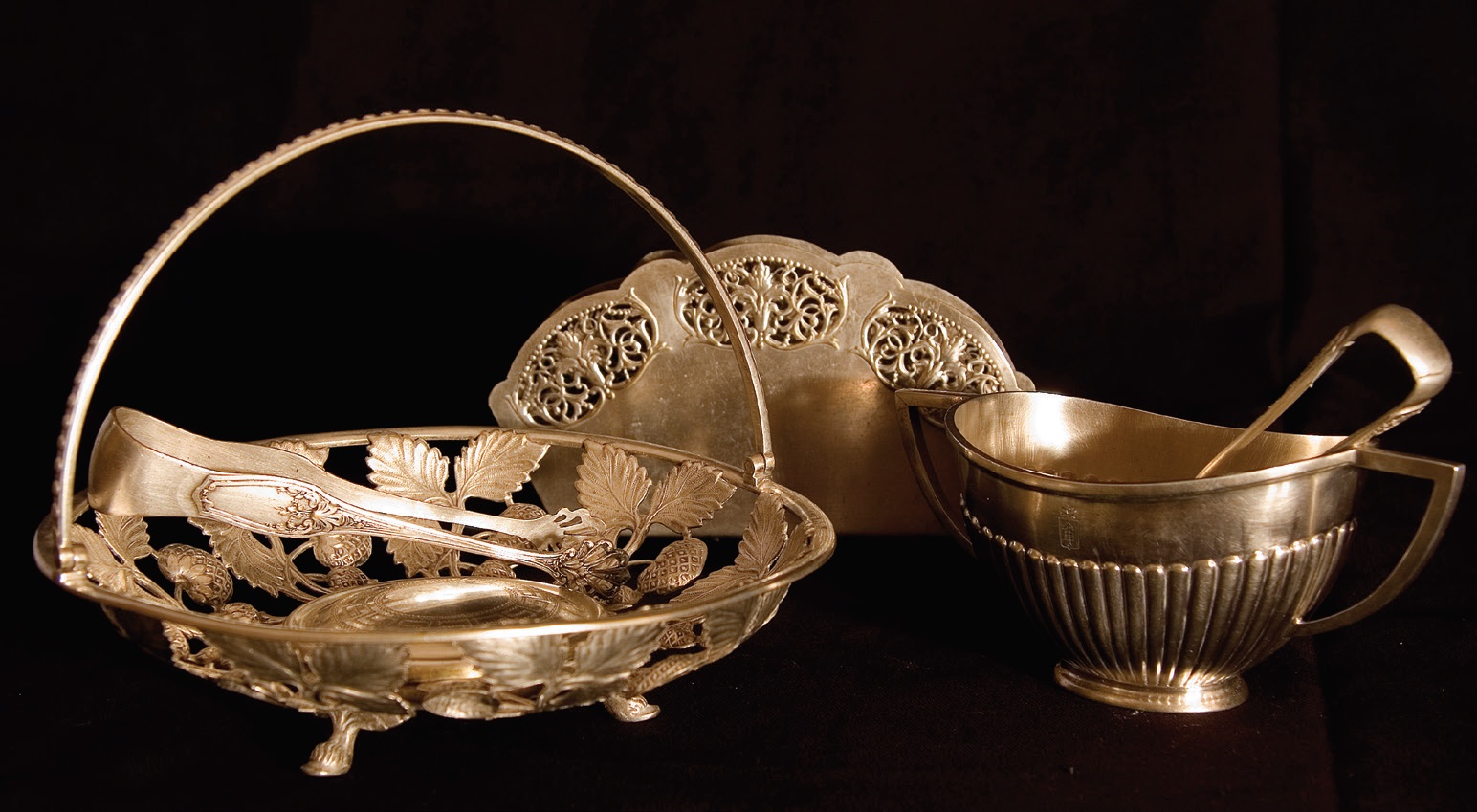 Stalo sidabras, tarp jų – krepšelis desertams patiekti, cukraus žnyplės. Rokiškio krašto muziejus